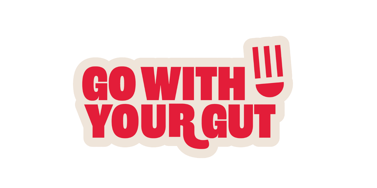 Red text reads "GO WITH YOUR GUT" on a white background, with the letter "U" in "GUT" stylized to resemble a smiling face and a fork above it, resembling a tongue or mouth.